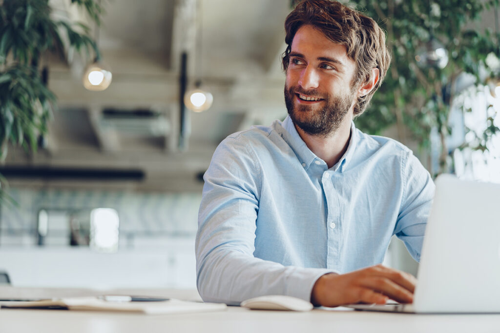 Businessman in shirt working on his laptop in an office