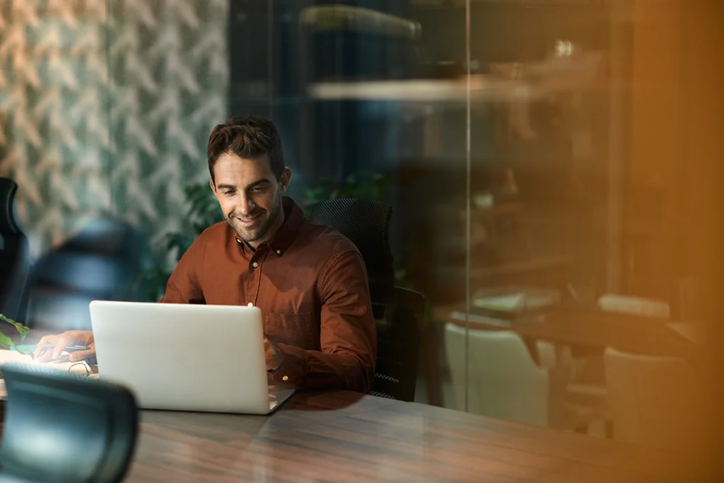 Businessman using Laptop While Working Late in his Office